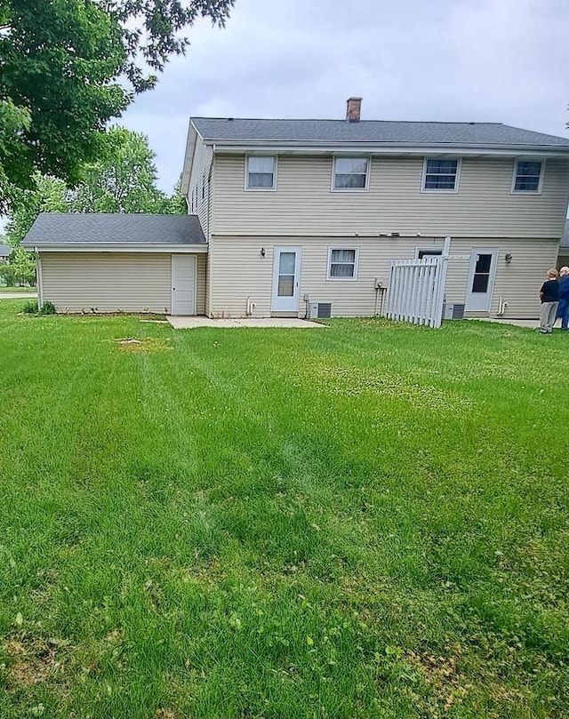 752 Imperial Ct Unit 754, West Bend, WI 53095 - rear view of house featuring a lawn, a chimney, and a patio area