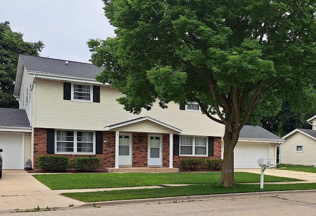 752 Imperial Ct Unit 754, West Bend, WI 53095 - view of front of house with driveway, a garage, brick siding, and a front lawn