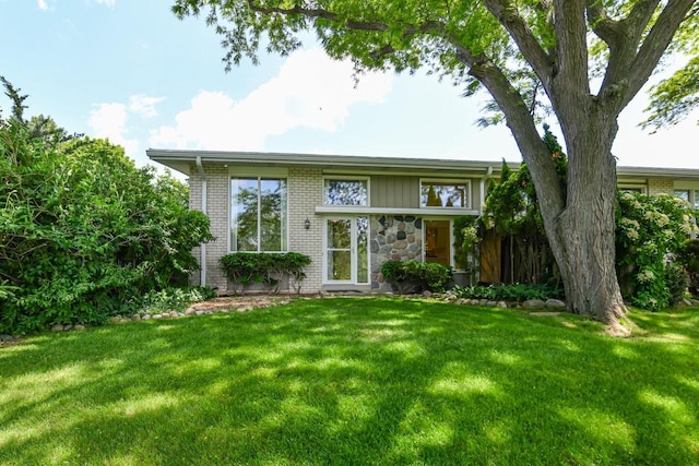 12929 N Colony Dr, Mequon, WI 53097 - view of front facade featuring a front lawn, brick siding, and stone siding