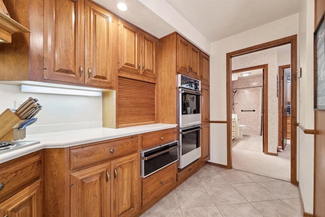 2213 Sunrise Dr, Appleton, WI 54914 - kitchen featuring a warming drawer, white double oven, light countertops, light tile patterned floors, and brown cabinets