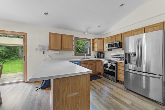 15 Naylor Cir, Madison, WI 53719 - kitchen with appliances with stainless steel finishes, a peninsula, lofted ceiling, light wood-style flooring, and light countertops