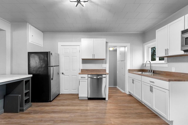 206 W Willow St, Bear Creek, WI 54922 - kitchen with stainless steel appliances, wood counters, light wood-style floors, and white cabinetry