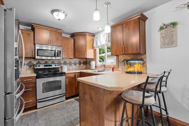 1918 Wilson Ave, Sheboygan, WI 53081 - kitchen with stainless steel appliances, a peninsula, light countertops, and brown cabinets