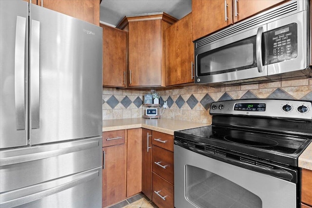 1918 Wilson Ave, Sheboygan, WI 53081 - kitchen with appliances with stainless steel finishes, light countertops, tasteful backsplash, and brown cabinetry
