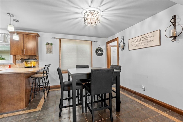 1918 Wilson Ave, Sheboygan, WI 53081 - dining space with dark tile patterned floors and a chandelier