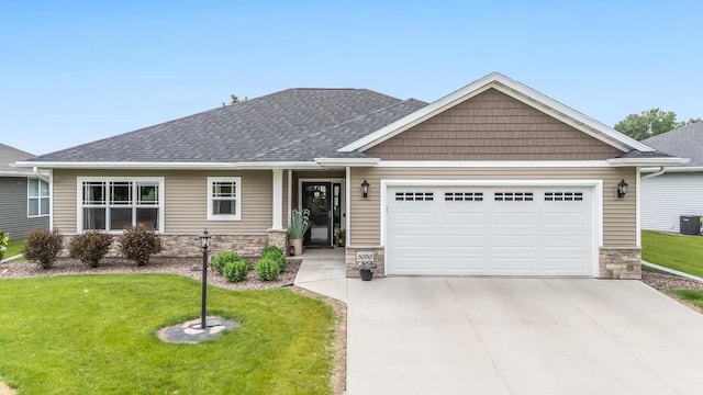 5090 N Milkweed Trl, Appleton, WI 54913 - craftsman-style house featuring a garage, concrete driveway, stone siding, a front lawn, and a shingled roof