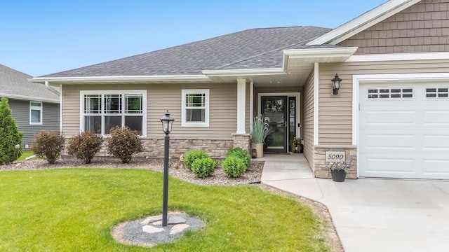 5090 N Milkweed Trl, Appleton, WI 54913 - view of exterior entry with stone siding, a yard, a shingled roof, and a garage