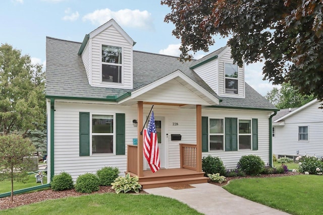 228 N Pleasant Ave, Jefferson, WI 53549 - cape cod home featuring a front lawn and roof with shingles