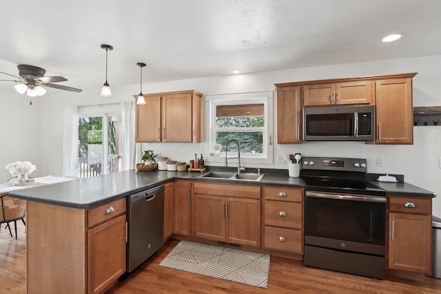 228 N Pleasant Ave, Jefferson, WI 53549 - kitchen featuring appliances with stainless steel finishes, a peninsula, dark countertops, healthy amount of natural light, and recessed lighting