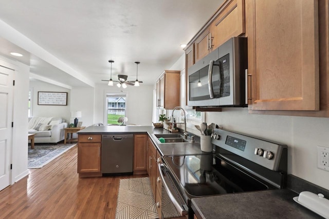 228 N Pleasant Ave, Jefferson, WI 53549 - kitchen with appliances with stainless steel finishes, a peninsula, dark wood-style flooring, dark countertops, and a ceiling fan