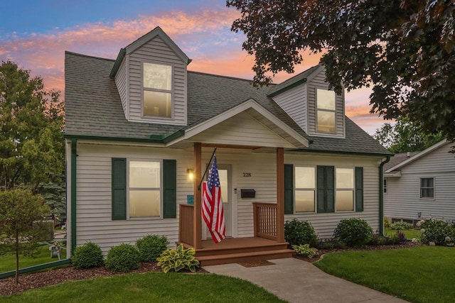 228 N Pleasant Ave, Jefferson, WI 53549 - view of front of property with a front lawn, a shingled roof, and covered porch