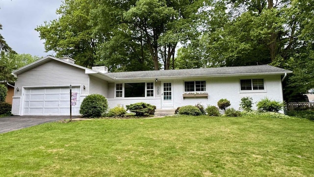 3218 N 13th St, Wausau, WI 54403 - ranch-style home featuring a garage, asphalt driveway, a front yard, and a chimney