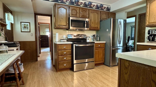 3218 N 13th St, Wausau, WI 54403 - kitchen with appliances with stainless steel finishes, light countertops, light wood finished floors, and a wainscoted wall
