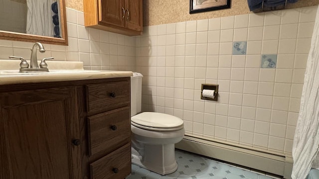 3218 N 13th St, Wausau, WI 54403 - bathroom with a baseboard heating unit, vanity, tile walls, tile patterned floors, and tasteful backsplash