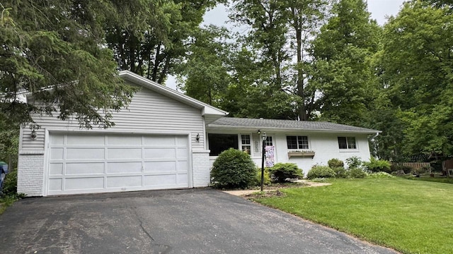 3218 N 13th St, Wausau, WI 54403 - view of front of property with brick siding, asphalt driveway, a front lawn, and an attached garage