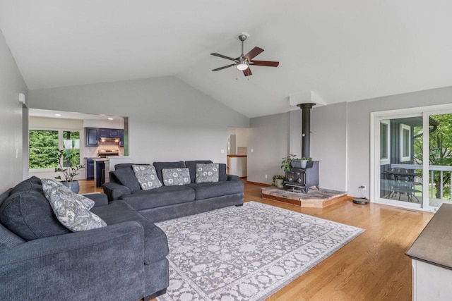 S83W27815 Beaver Trl, Mukwonago, WI 53149 - living area featuring a wood stove, vaulted ceiling, ceiling fan, light wood-style floors, and healthy amount of natural light
