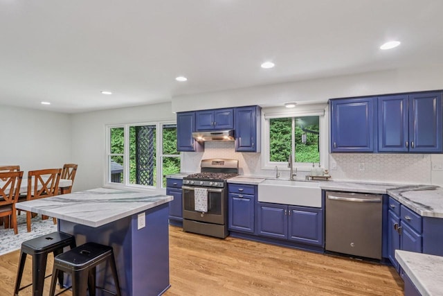 S83W27815 Beaver Trl, Mukwonago, WI 53149 - kitchen with stainless steel appliances, under cabinet range hood, blue cabinetry, plenty of natural light, and recessed lighting