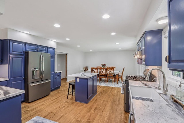 S83W27815 Beaver Trl, Mukwonago, WI 53149 - kitchen with stainless steel appliances, a breakfast bar, a center island, light wood finished floors, and recessed lighting