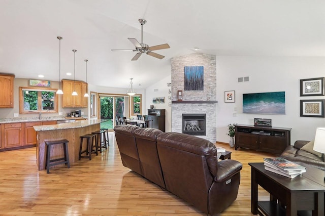 3176 Weybridge Dr, Sun Prairie, WI 53590 - living area with light wood-style floors, ceiling fan, a fireplace, recessed lighting, and high vaulted ceiling