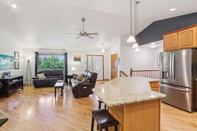 3176 Weybridge Dr, Sun Prairie, WI 53590 - kitchen featuring stainless steel fridge with ice dispenser, lofted ceiling, a center island, a ceiling fan, and light wood-type flooring