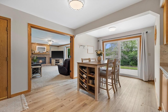 W163N10515 Ridgeview Ln, Germantown, WI 53022 - dining room with light wood-style floors, a fireplace, and ceiling fan