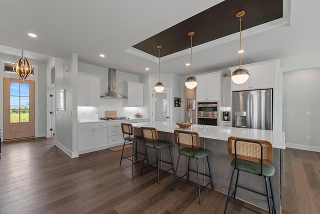 N55W19373 Red Crown Ln, Menomonee Falls, WI 53051 - kitchen with wall chimney exhaust hood, stainless steel appliances, a raised ceiling, dark wood-style flooring, and white cabinets