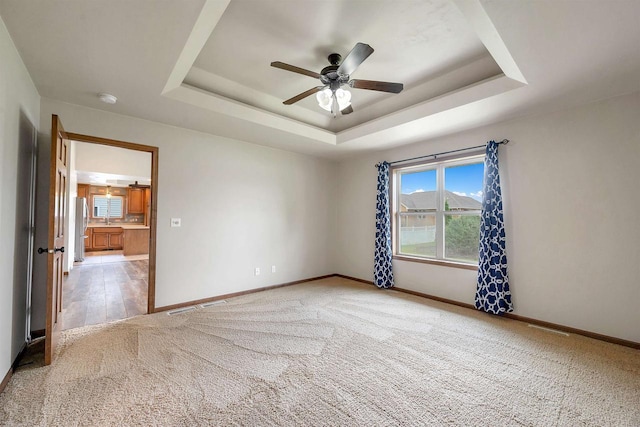 4815 Isabella Cir, Oneida, WI 54155 - unfurnished room featuring light colored carpet, a tray ceiling, ceiling fan, and a smoke detector