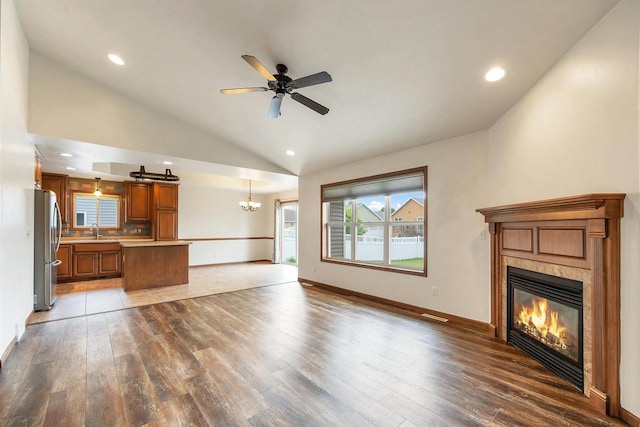 4815 Isabella Cir, Oneida, WI 54155 - unfurnished living room featuring a fireplace, hardwood / wood-style flooring, vaulted ceiling, a ceiling fan, and a chandelier