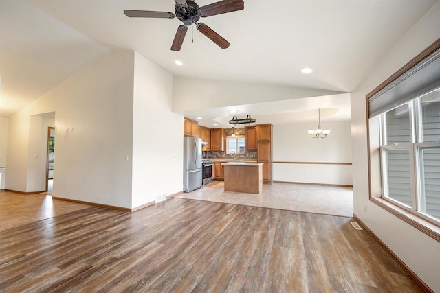 4815 Isabella Cir, Oneida, WI 54155 - unfurnished living room with vaulted ceiling, a chandelier, light wood-style flooring, ceiling fan, and recessed lighting