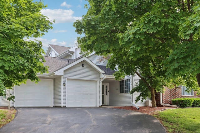 735 Cherokee Path, Lake Mills, WI 53551 - view of property hidden behind natural elements with an attached garage, driveway, and a shingled roof