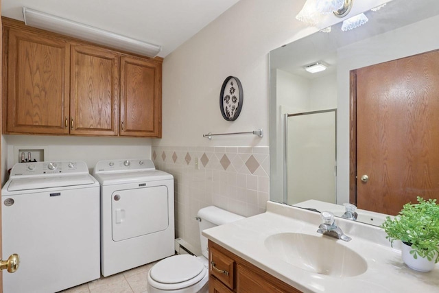 735 Cherokee Path, Lake Mills, WI 53551 - bathroom featuring washer and dryer, a shower stall, vanity, tile walls, and tile patterned floors