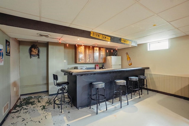 215 Marcoe St, Fond Du Lac, WI 54937 - indoor bar featuring freestanding refrigerator, finished concrete floors, a paneled ceiling, and wooden walls