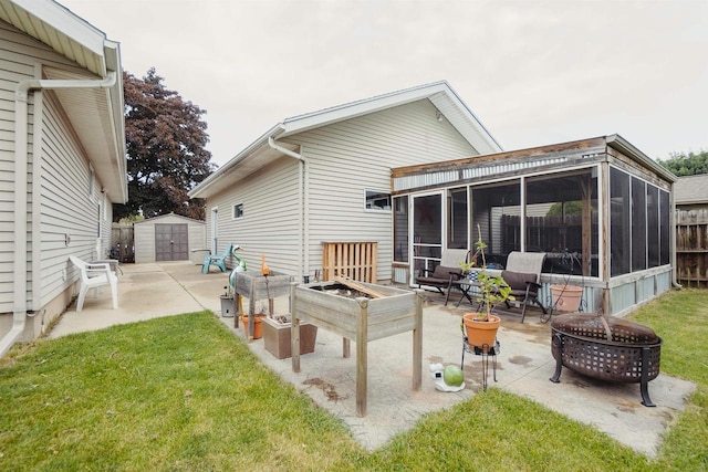 215 Marcoe St, Fond Du Lac, WI 54937 - back of property with a fire pit, a sunroom, a patio, a shed, and a lawn