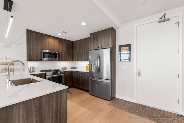 324 N Lake St Unit 204, Port Washington, WI 53074 - kitchen featuring stainless steel appliances, light wood finished floors, modern cabinets, dark brown cabinetry, and recessed lighting