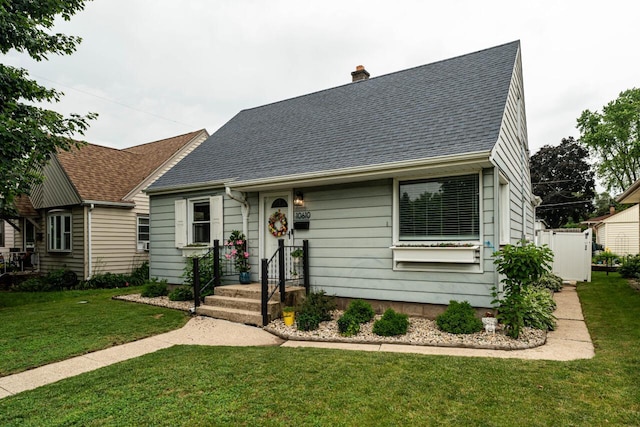 10610 W Rogers St, West Allis, WI 53227 - cape cod-style house with a shingled roof, a front lawn, and a chimney