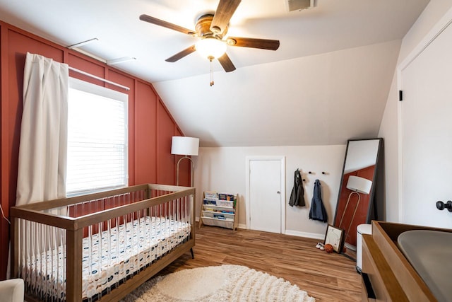 10610 W Rogers St, West Allis, WI 53227 - bedroom with light wood finished floors, vaulted ceiling, a nursery area, and a ceiling fan