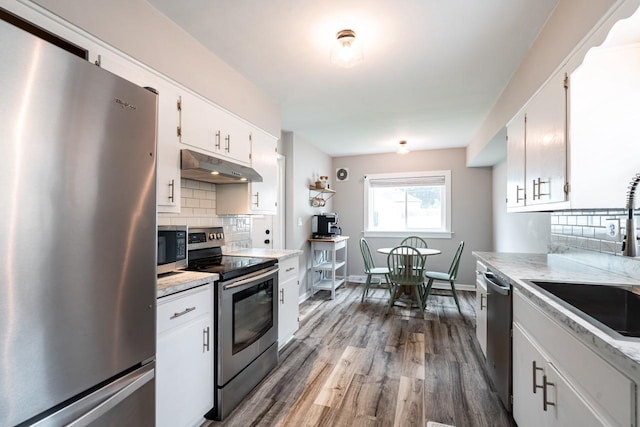 10610 W Rogers St, West Allis, WI 53227 - kitchen with stainless steel appliances, under cabinet range hood, light countertops, decorative backsplash, and white cabinetry