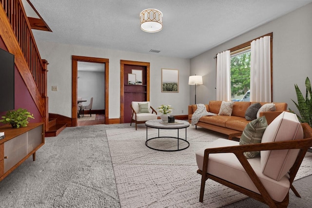 102 10th St, Clintonville, WI 54929 - living room with stairs, a textured ceiling, and carpet flooring
