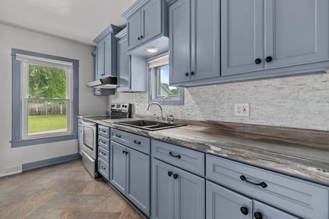102 10th St, Clintonville, WI 54929 - kitchen featuring stainless steel electric stove, under cabinet range hood, plenty of natural light, and decorative backsplash