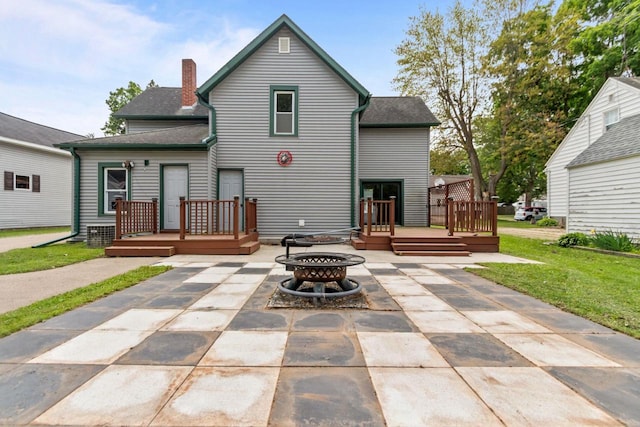 102 10th St, Clintonville, WI 54929 - back of house with an outdoor fire pit, a patio, a wooden deck, a lawn, and a chimney