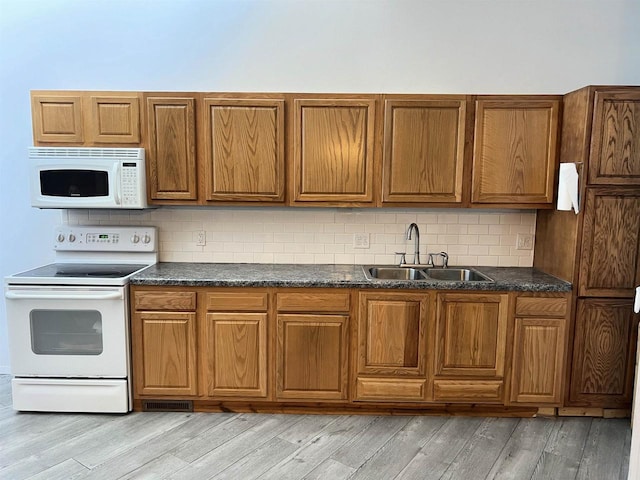 2400 Church St, Stevens Point, WI 54481 - kitchen with white appliances, brown cabinets, dark countertops, light wood-type flooring, and backsplash