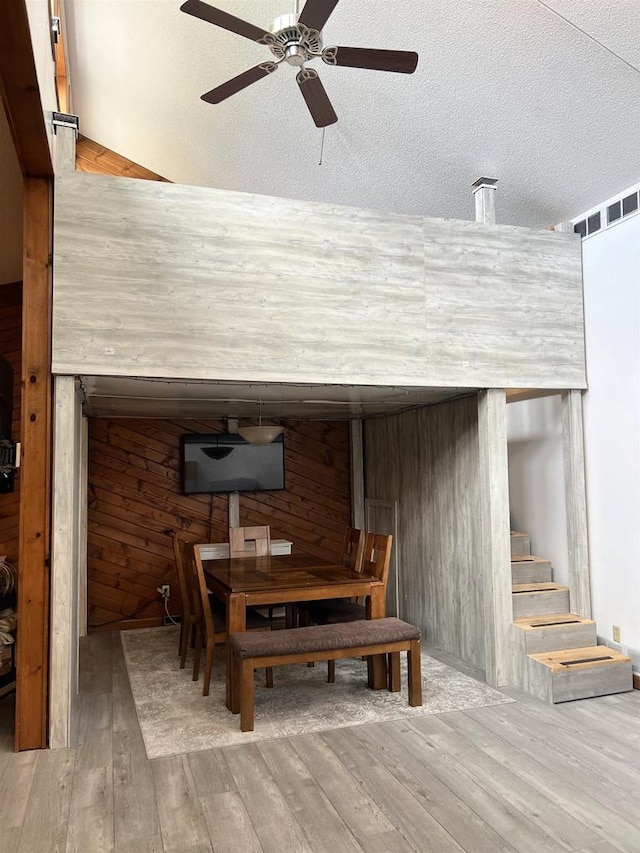 2400 Church St, Stevens Point, WI 54481 - dining room with ceiling fan, hardwood / wood-style flooring, stairway, wood walls, and a textured ceiling