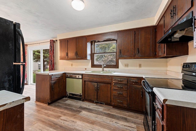 1517 Navarino St, Algoma, WI 54201 - kitchen featuring black appliances, under cabinet range hood, light countertops, and light wood-style floors