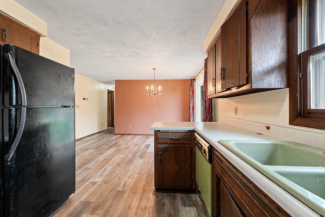 1517 Navarino St, Algoma, WI 54201 - kitchen with freestanding refrigerator, dishwasher, a chandelier, light countertops, and light wood finished floors