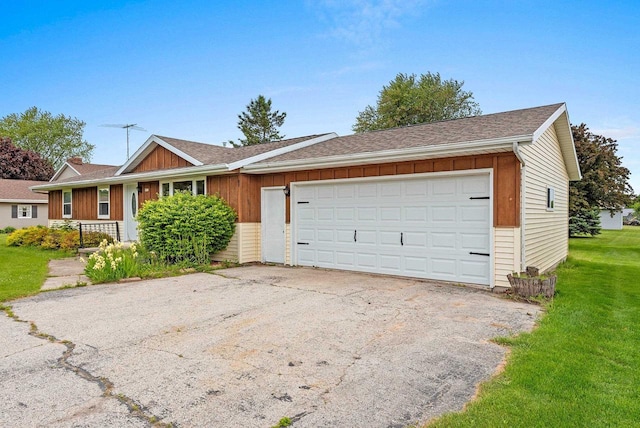 1517 Navarino St, Algoma, WI 54201 - ranch-style house with an attached garage, a front lawn, asphalt driveway, and board and batten siding