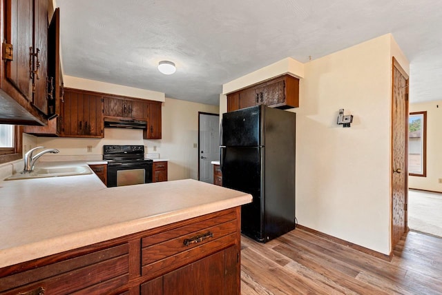1517 Navarino St, Algoma, WI 54201 - kitchen featuring black appliances, range hood, light wood-style floors, and light countertops