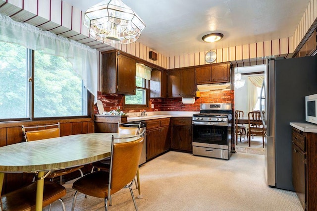 9600 W Debbie Ln, Milwaukee, WI 53224 - kitchen with appliances with stainless steel finishes, under cabinet range hood, light countertops, light colored carpet, and a chandelier