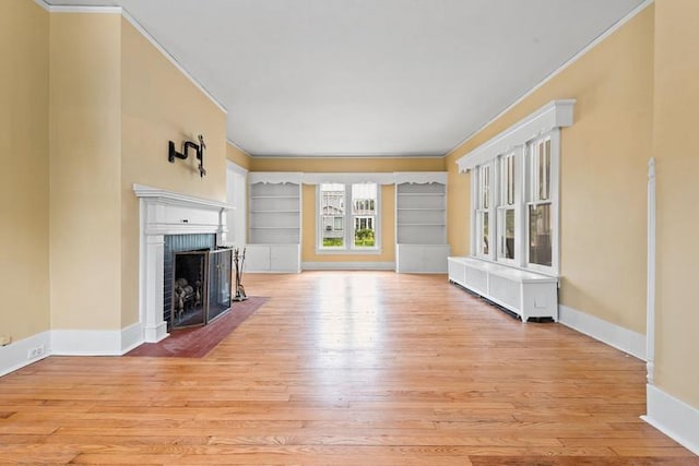 701 N 7th St, Manitowoc, WI 54220 - unfurnished living room with ornamental molding, light wood-style floors, a fireplace, and built in features