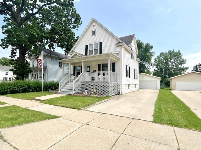 154 W Arndt St, Fond Du Lac, WI 54935 - view of front facade featuring a porch, a detached garage, an outbuilding, and a front yard