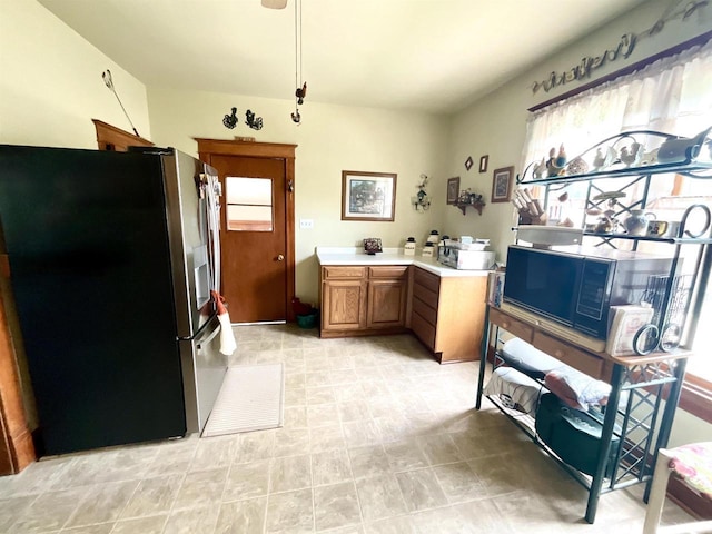 154 W Arndt St, Fond Du Lac, WI 54935 - kitchen with stainless steel fridge with ice dispenser, light countertops, black microwave, and brown cabinetry